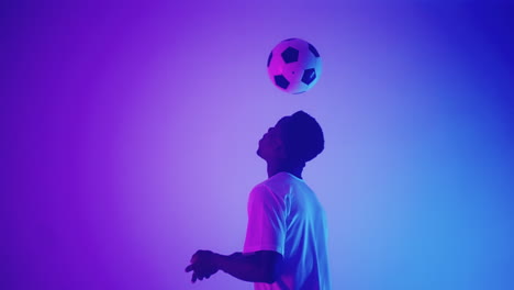 african-footballer-is-kicking-up-ball-by-heads-in-studio-doing-keppie-uppie-skill-for-field-player